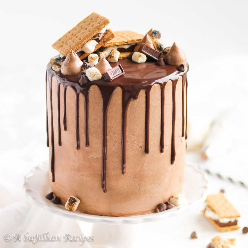Layers of fluffy graham cracker-flavored cake and toasted marshmallow mousse frosted in a milk chocolate Swiss meringue buttercream and enrobed in a rich chocolate ganache! Oh, and don’t forget about the ooey gooey s’mores on top!