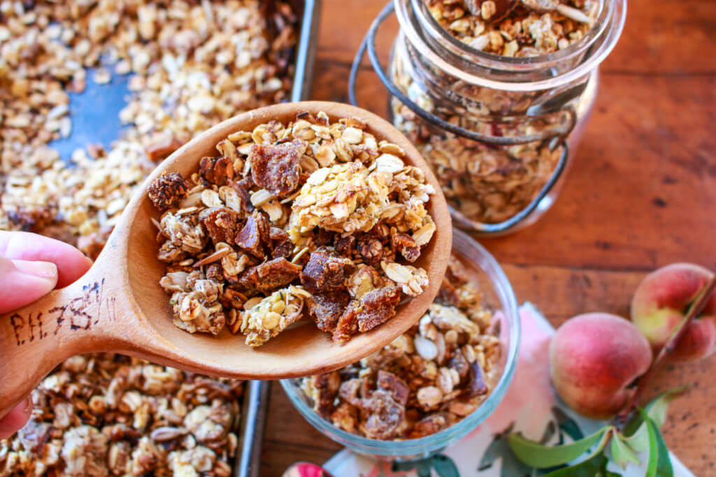 You can make the best home-crafted granola ever by doing it yourself with just a few ingredients you might have in your pantry right now! This super easy, sunny recipe for Ginger Peach Sunflower Granola will brighten up any morning